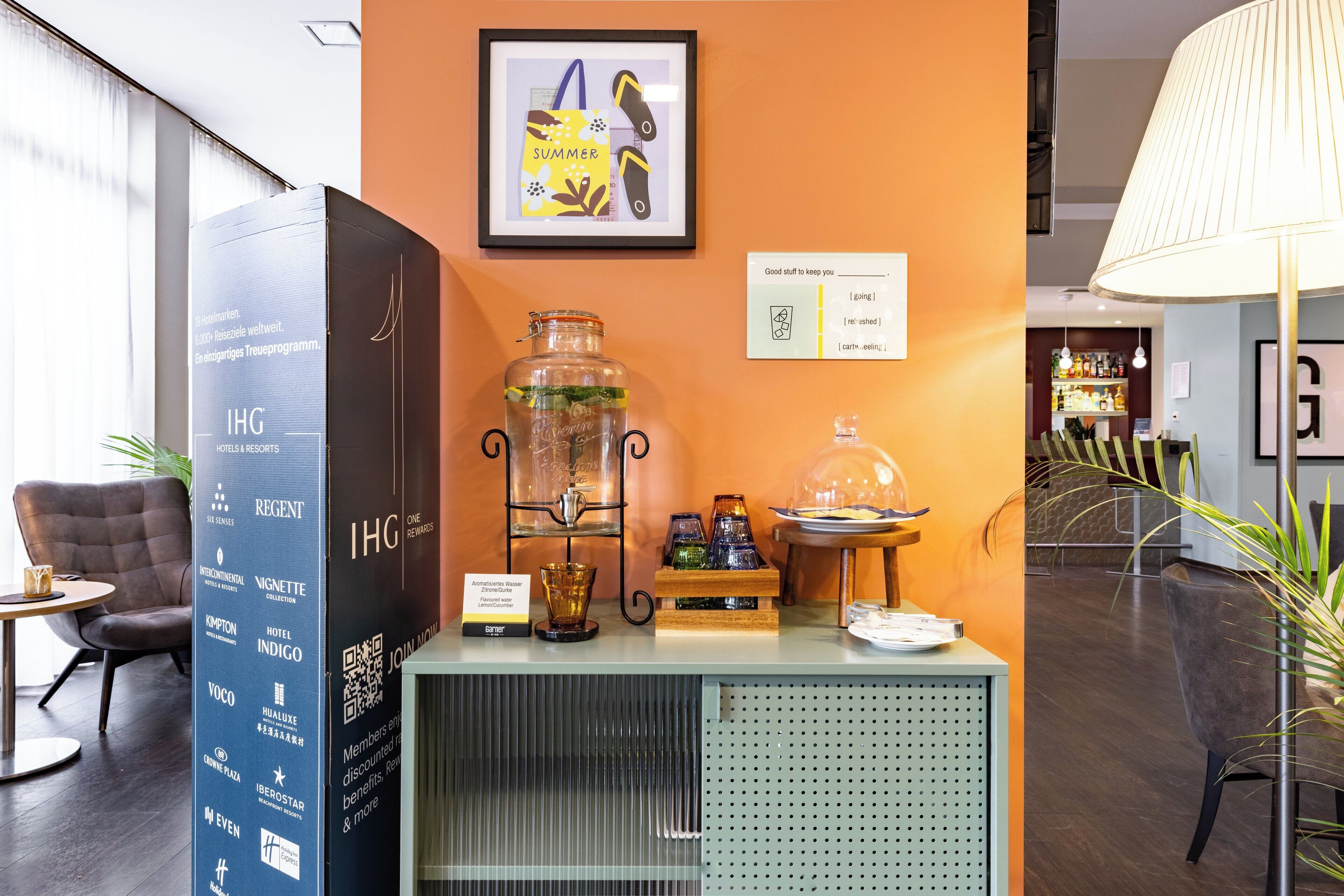 A reception desk with a framed 'Summer' sign, a glass jar, and a lamp.
