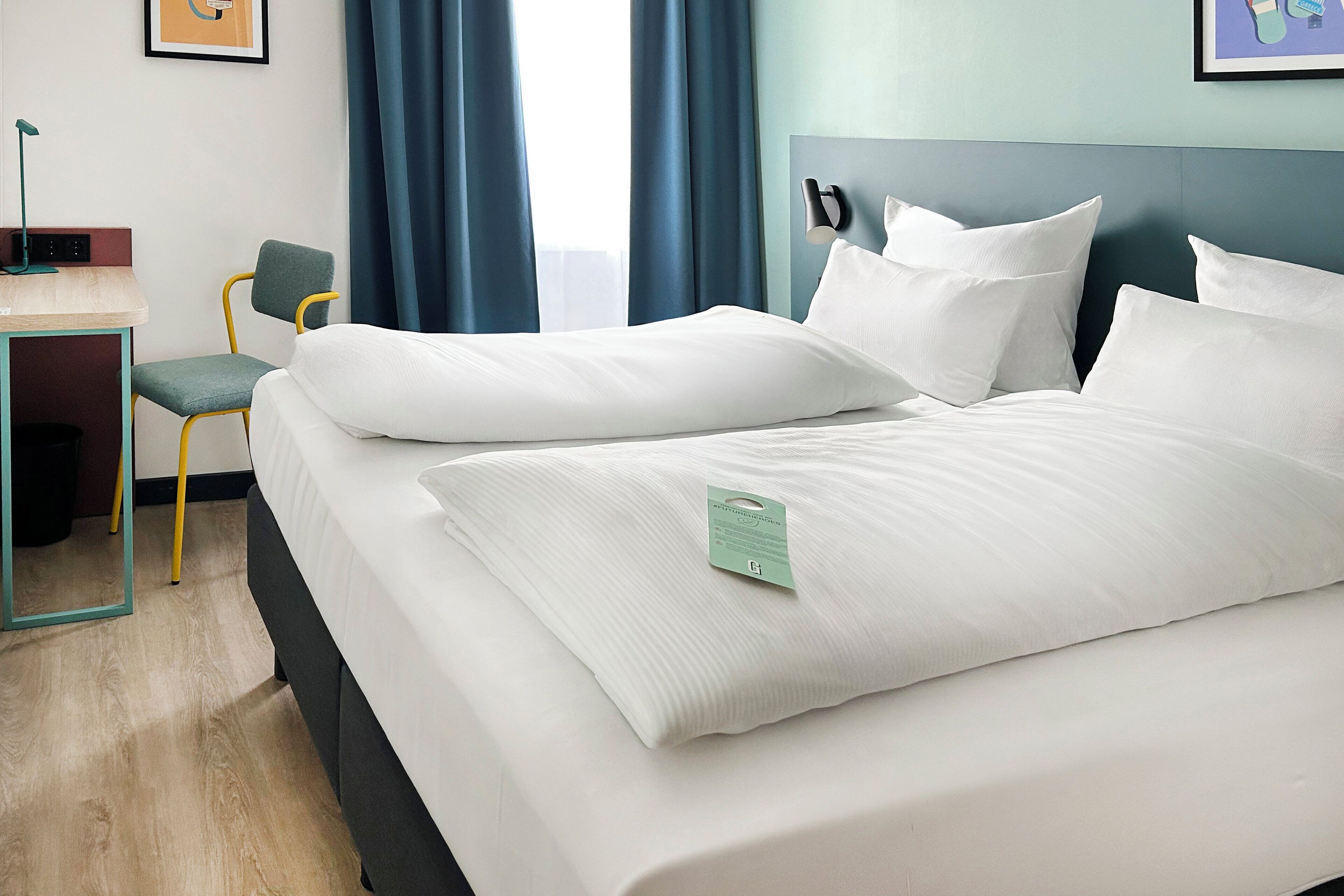 A hotel room with a bed, a desk, and a chair.