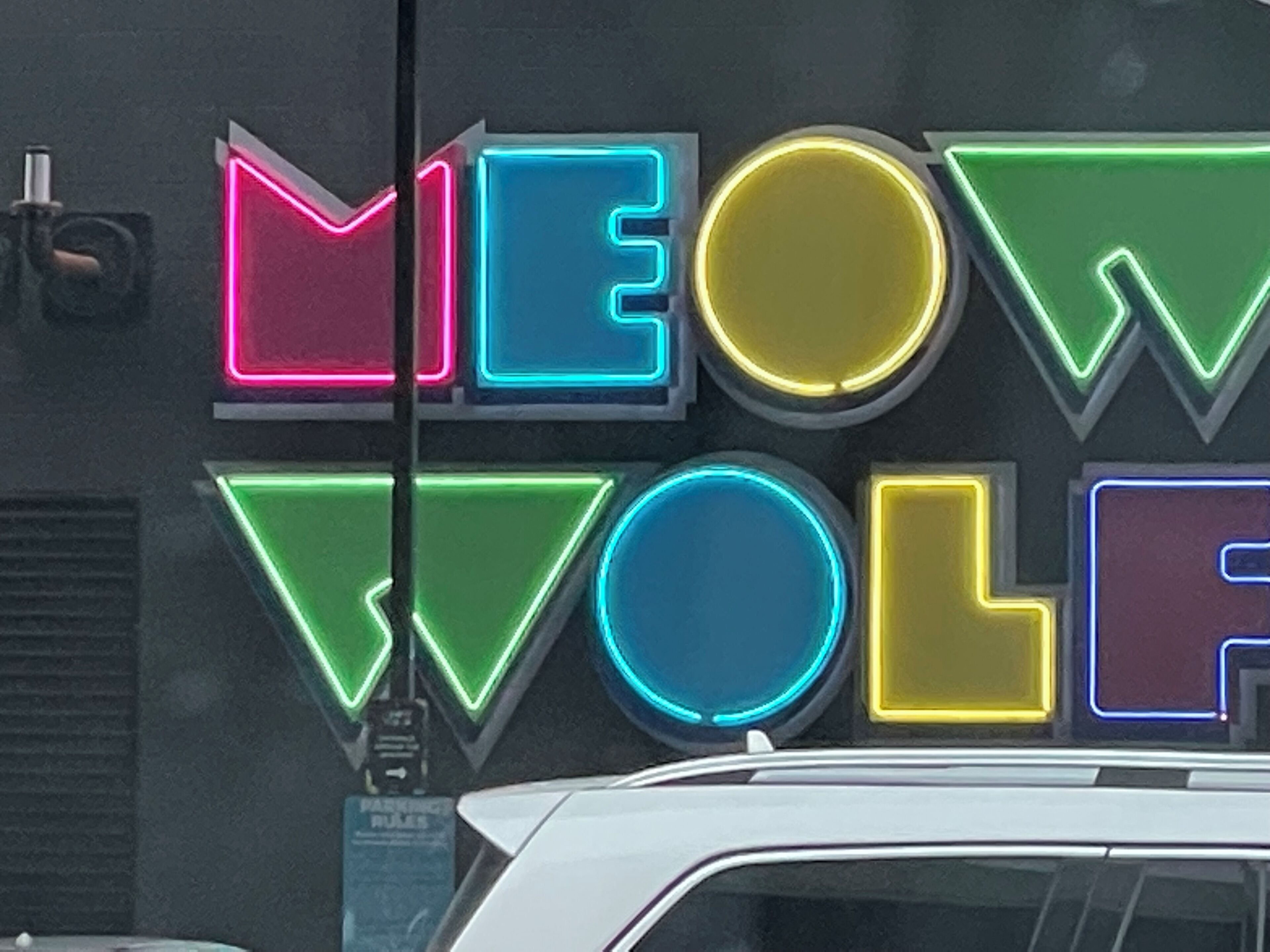 En neonskilte med ordene "MEOW VOLE" i farverige bogstaver.