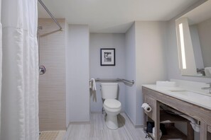 A modern bathroom with a shower, toilet, and sink.