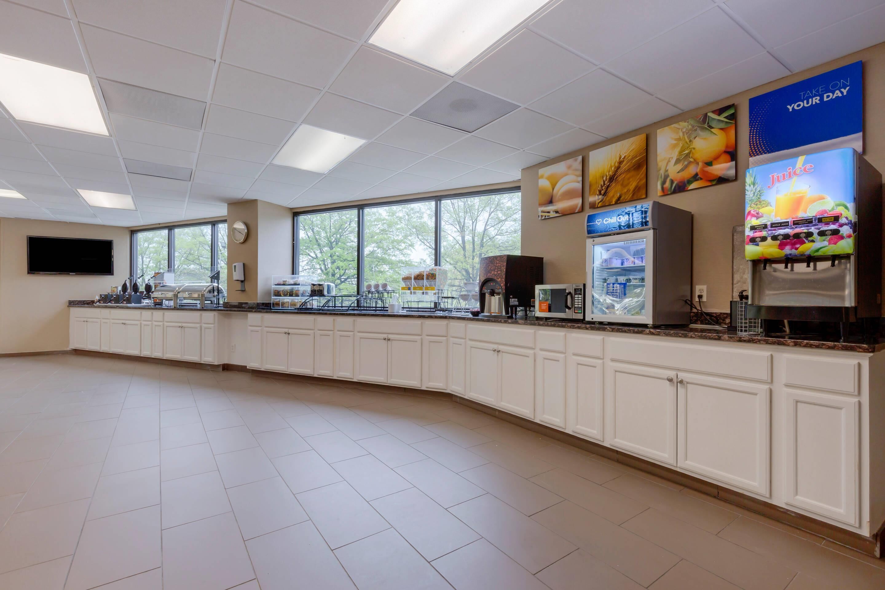 A spacious kitchen area with a long counter, equipped with various appliances and a beverage dispenser.