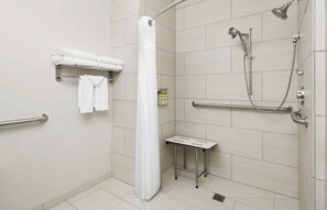 A shower area with a white shower curtain, a handheld showerhead, a handheld showerhead, and a grab bar. - Holiday Inn Express & Suites Valdosta West - Mall Area by IHG (Valdosta)