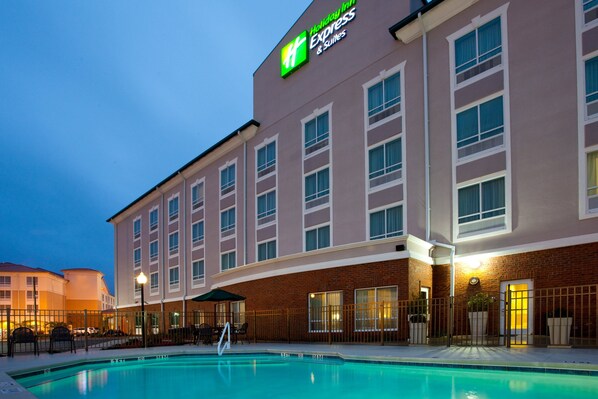 Un hotel Holiday Inn Express con piscina, múltiples ventanas y fachada de ladrillo.