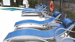 Ein Poolbereich mit Liegestühlen und einem Rettungsring.