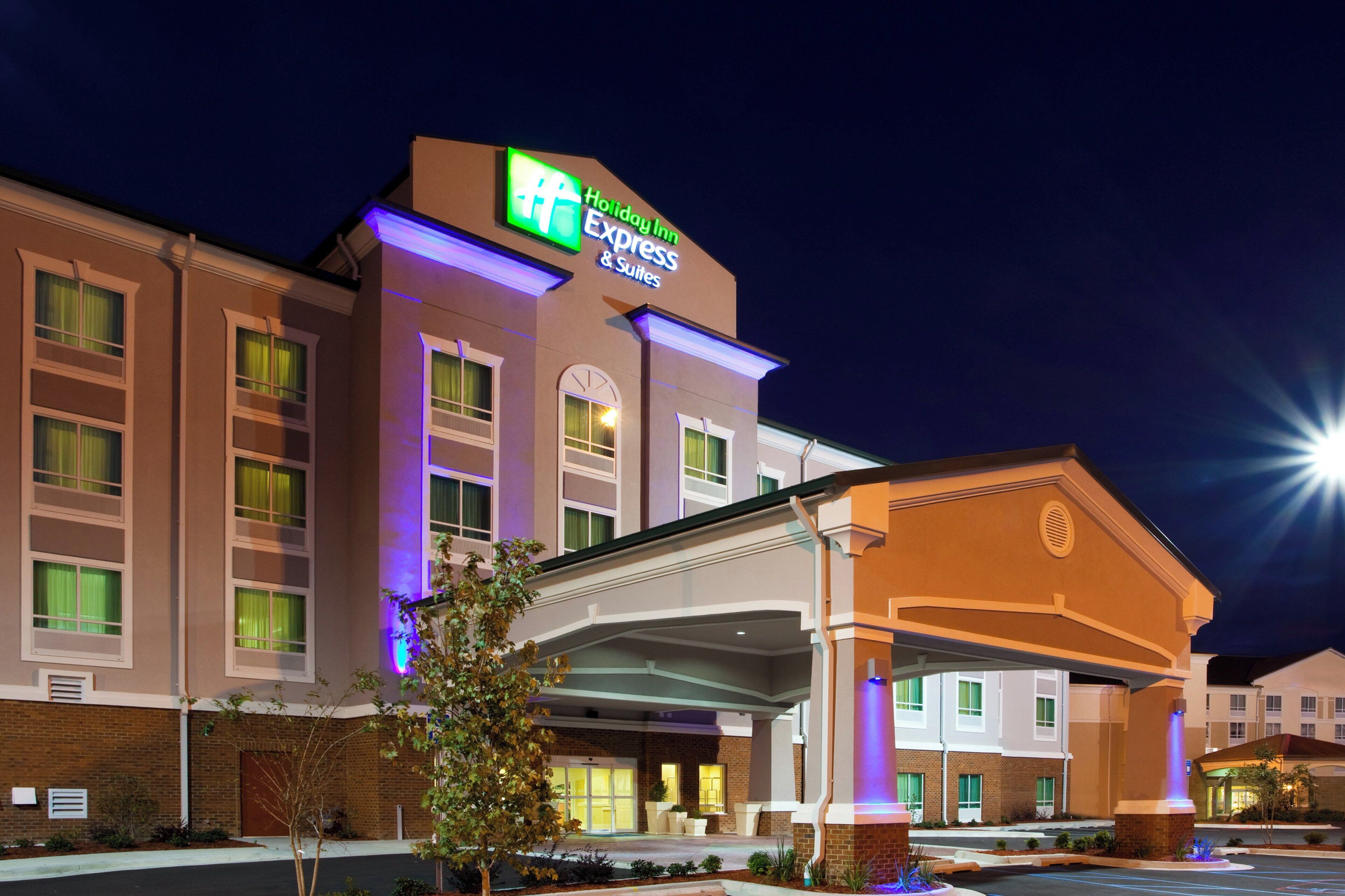 Um hotel Holiday Inn Express & Suites com fachada de tijolos, janelas amplas e entrada coberta.