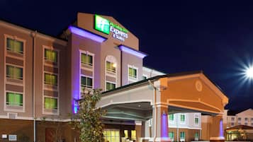 Um hotel Holiday Inn Express & Suites com fachada de tijolos, janelas amplas e entrada coberta.