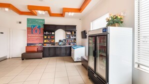 Eine geräumige Lobby mit großem K ühlschrank, Verkaufsautomaten und einer Sitzecke.