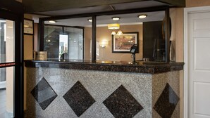 A reception area with a marble counter, a framed picture on the wall, and a telephone. - Best Western Executive Inn (Grove City)