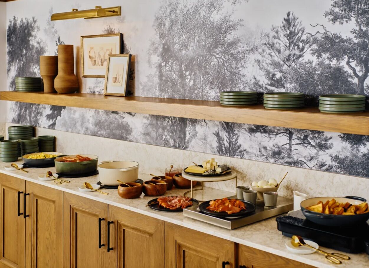 Un buffet avec différents plats et des plats de service disposés sur un comptoir.