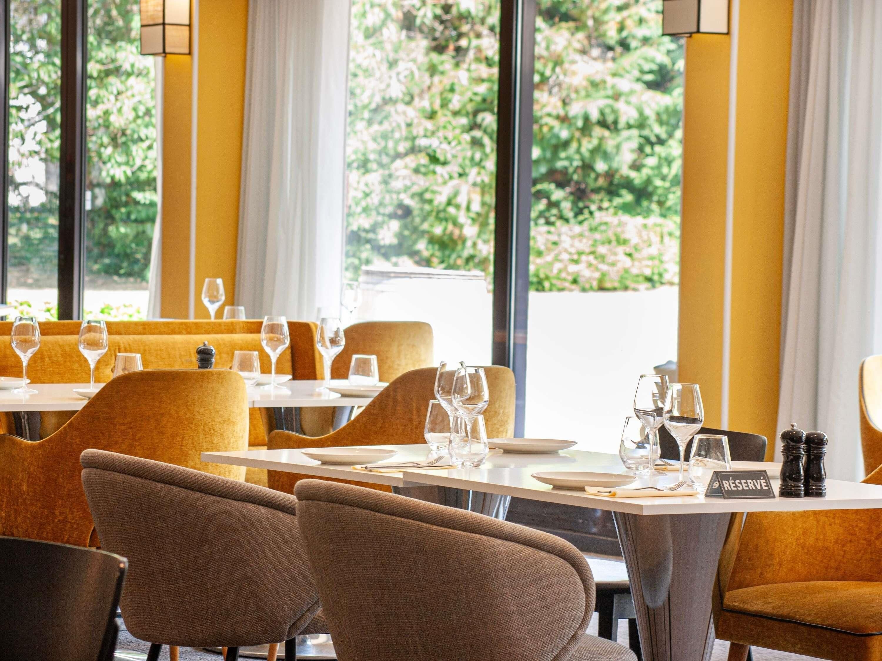 L’intérieur d’un restaurant, avec des tables dressées pour le service, des chaises et un panneau indiquant « RÉSERVÉ », signalant qu’une table est réservée.