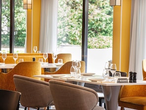 Interior de un restaurante con mesas preparadas para comer, sillas y un letrero que indica 'RESERVÉ'.