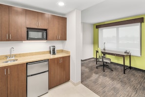 A kitchen with wooden cabinets, a built-in microwave, a coffee maker, and a dishwasher.