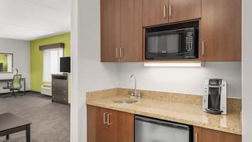 Una kitchenette equipada con microondas, cafetera y lavavajillas de acero inoxidable.