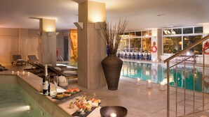 A poolside area with lounge chairs, a bar with drinks, and a large vase of branches. - Crowne Plaza Rome-St. Peter's Hotel & Spa by IHG (Rome)