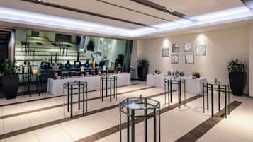 A modern interior with a central display area, multiple tables, and potted plants.