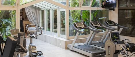 A gym with treadmills, stationary bikes, and a rowing machine.