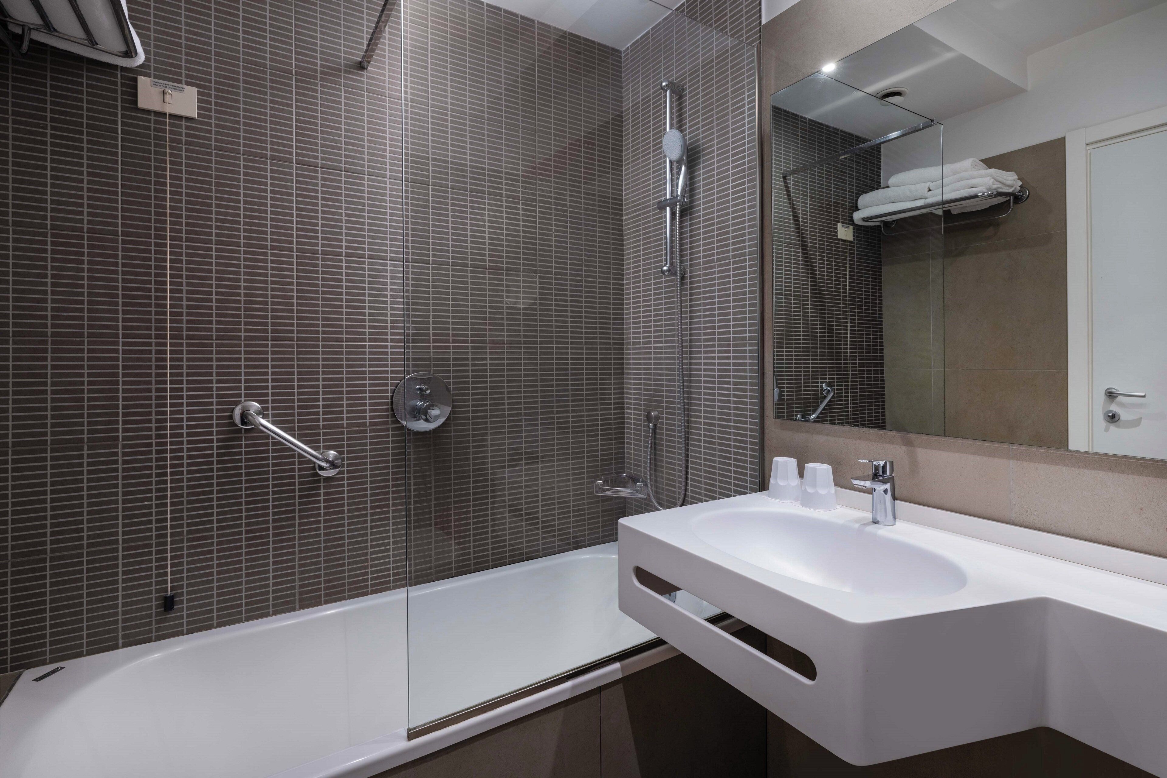 A modern bathroom with a bathtub, a sink, and a shower.