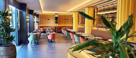 Un restaurante moderno con un amplio salón comedor, asientos con cojines y diversas opciones de asientos.