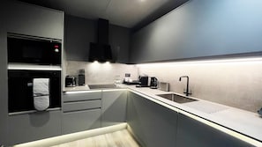A modern kitchen with a microwave, toaster, coffee maker, and sink. - DoubleTree by Hilton London Kensington (London)