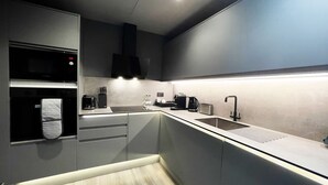 Une cuisine moderne équipée d’un four à micro-ondes, d’un grille-pain, d’une machine à café et d’un évier.