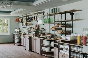 A modern kitchen with wooden shelves, glassware, and various kitchen items.
