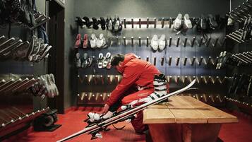 A ski storage area with skis and ski boots organized on racks.