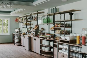 Kitchen area with ample storage solutions, featuring shelves and cabinets for kitchenware and fresh produce.