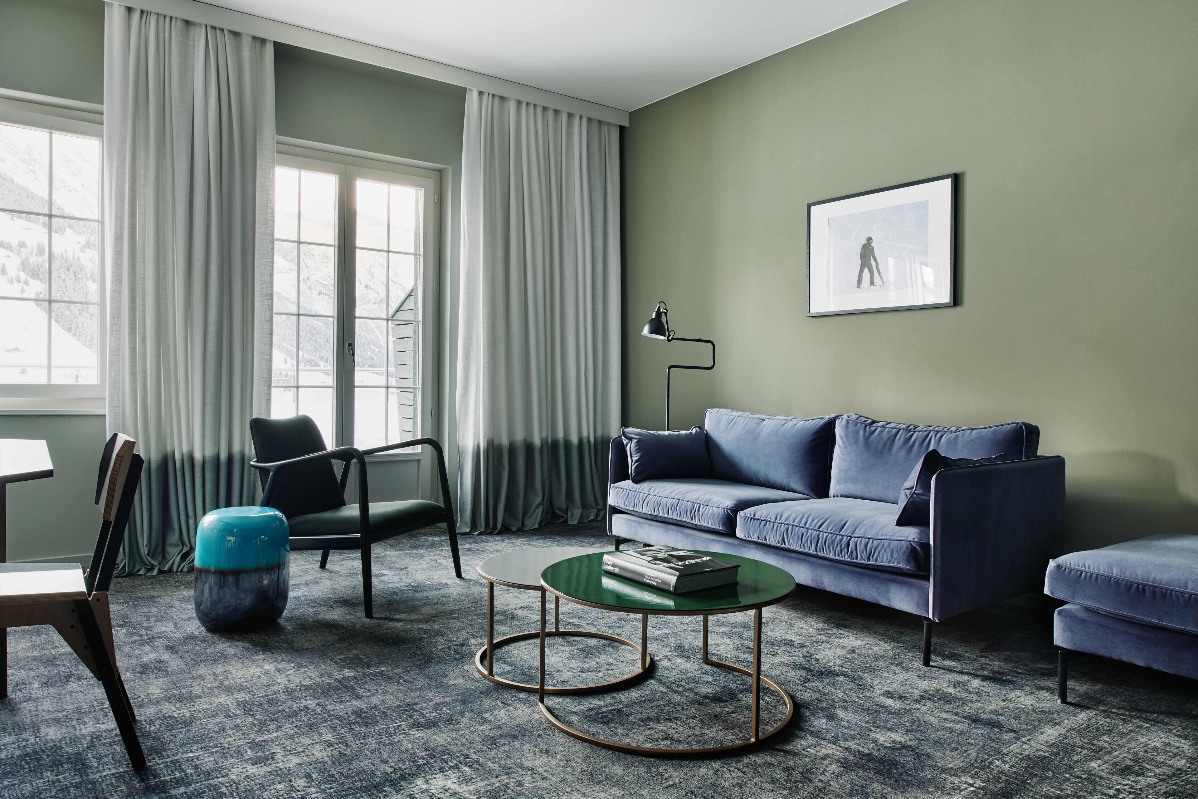 Un salon comprenant un canapé, un fauteuil, une table basse et une lampe.