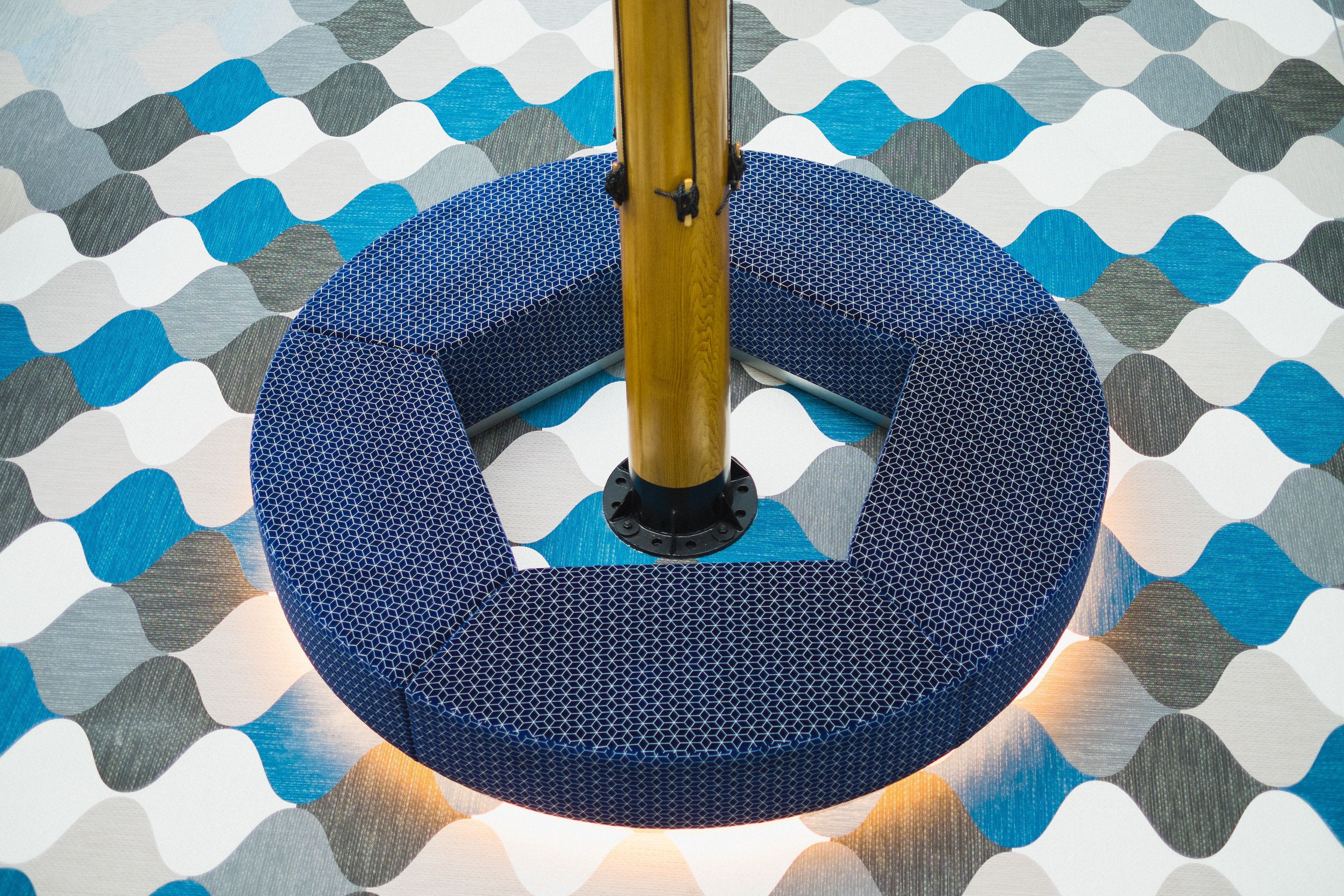 A circular blue object with a textured surface and a central pole.