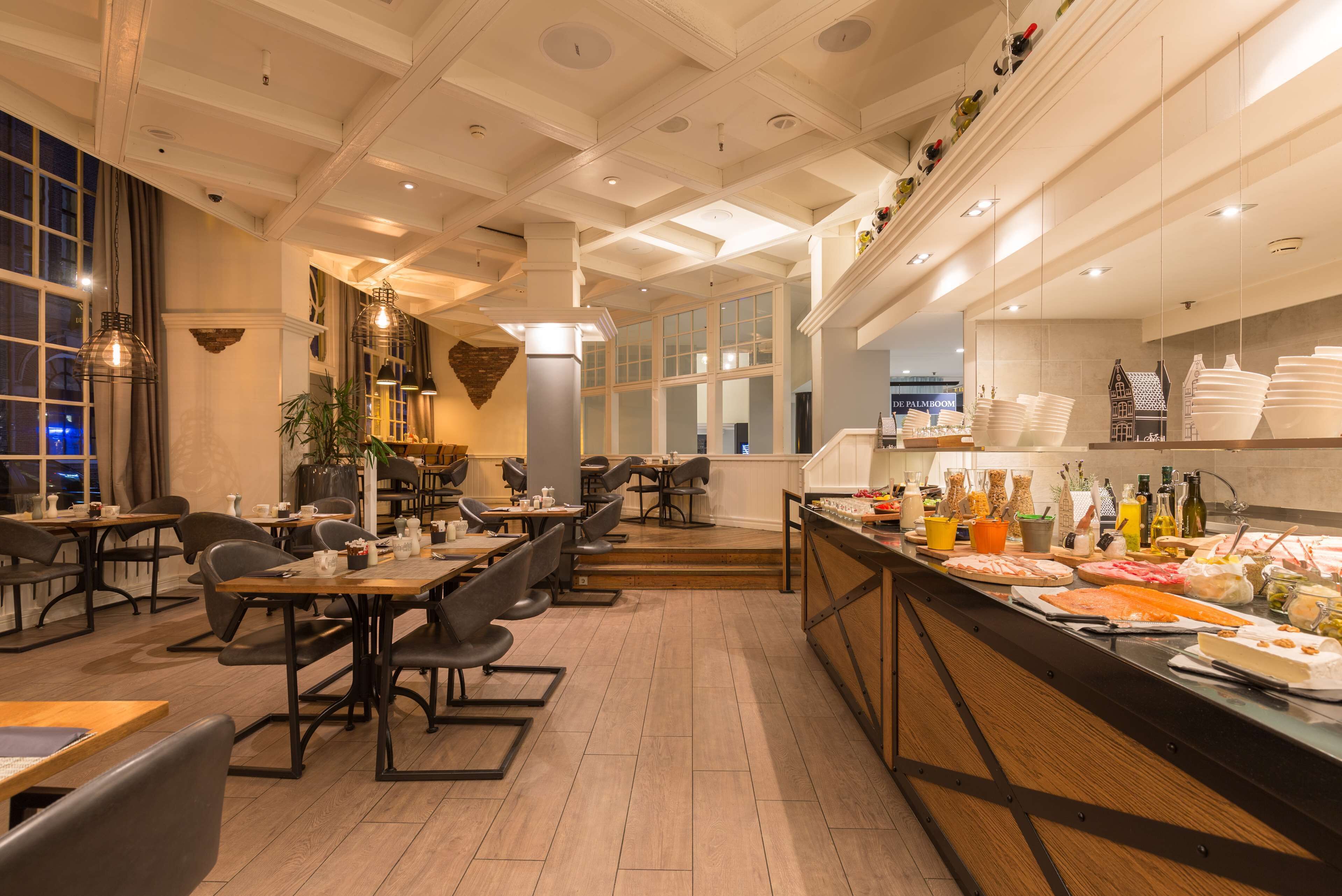 Ein Restaurant mit Holztischen und -stühlen, einer Buffettheke mit verschiedenen Speisen und einem modernen Innendesign.