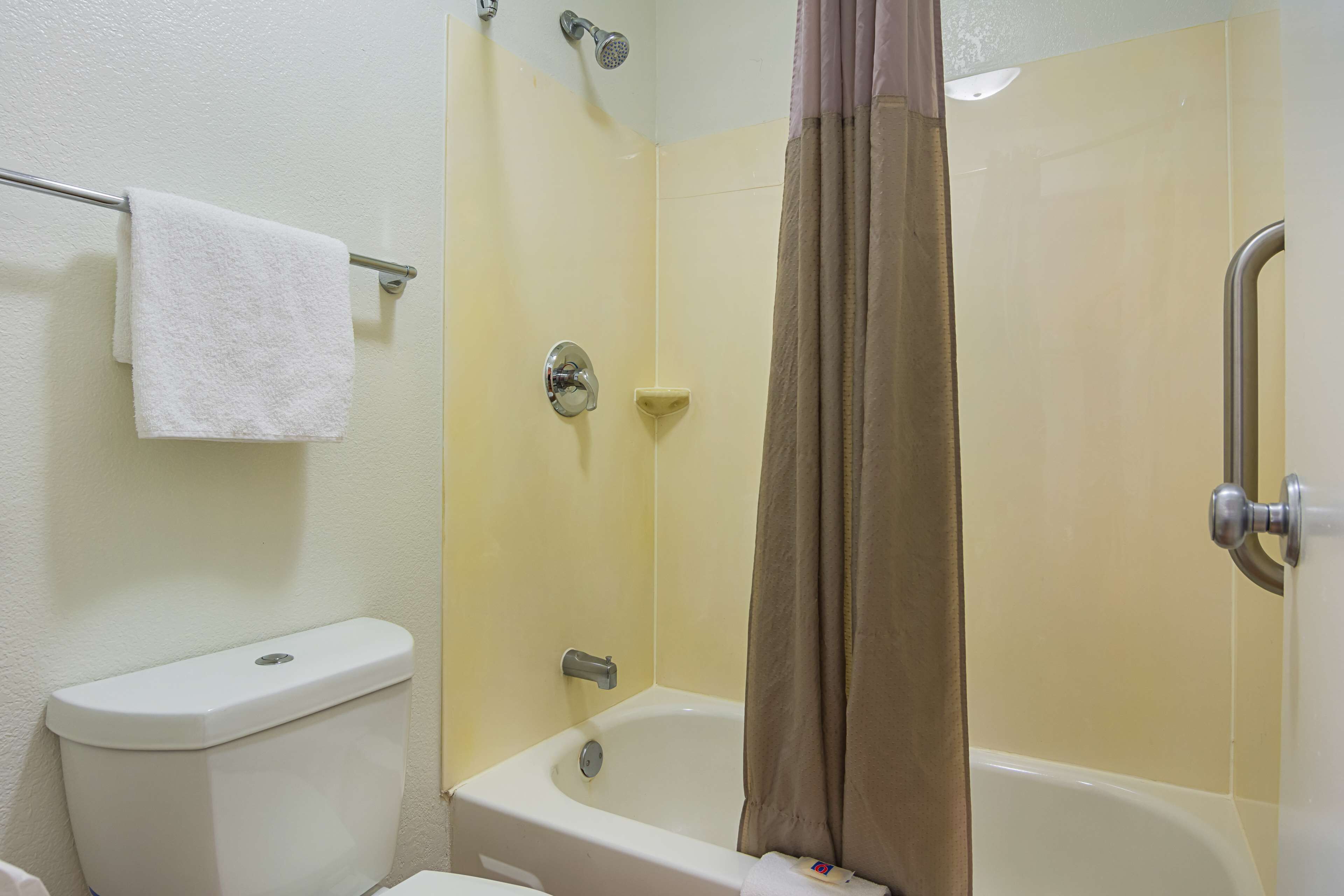 A bathroom with a toilet, a bathtub, and a shower curtain.
