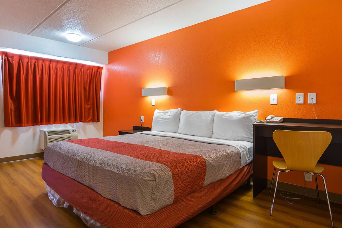 Une chambre d’hôtel avec un lit, un bureau et une chaise.