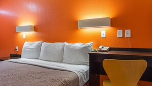 A hotel room with a bed, a desk with a chair, and a phone on the desk. - Motel 6 Tucker, GA - Atlanta Northeast (Tucker)