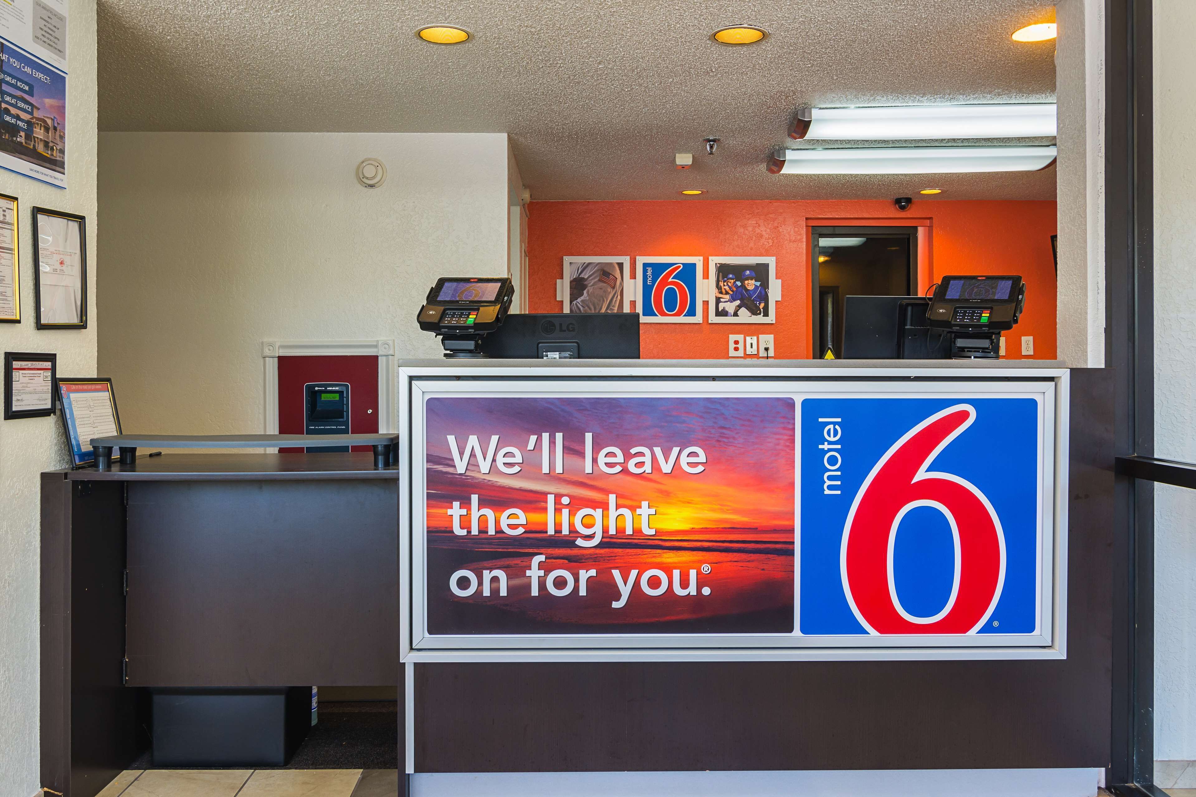 Mostrador de recepción de un motel con un letrero que dice: 'Dejaremos la luz encendida para usted'.