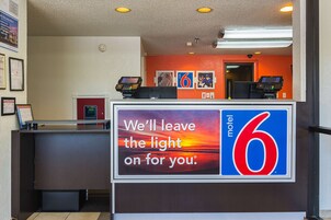 Mostrador de recepción de un motel con un letrero que dice: 'Dejaremos la luz encendida para usted'.