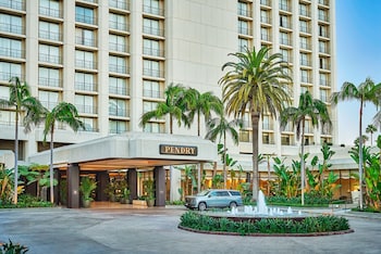 A hotel room with two beds, a desk, a chair, and a dining table. at Pendry Newport Beach