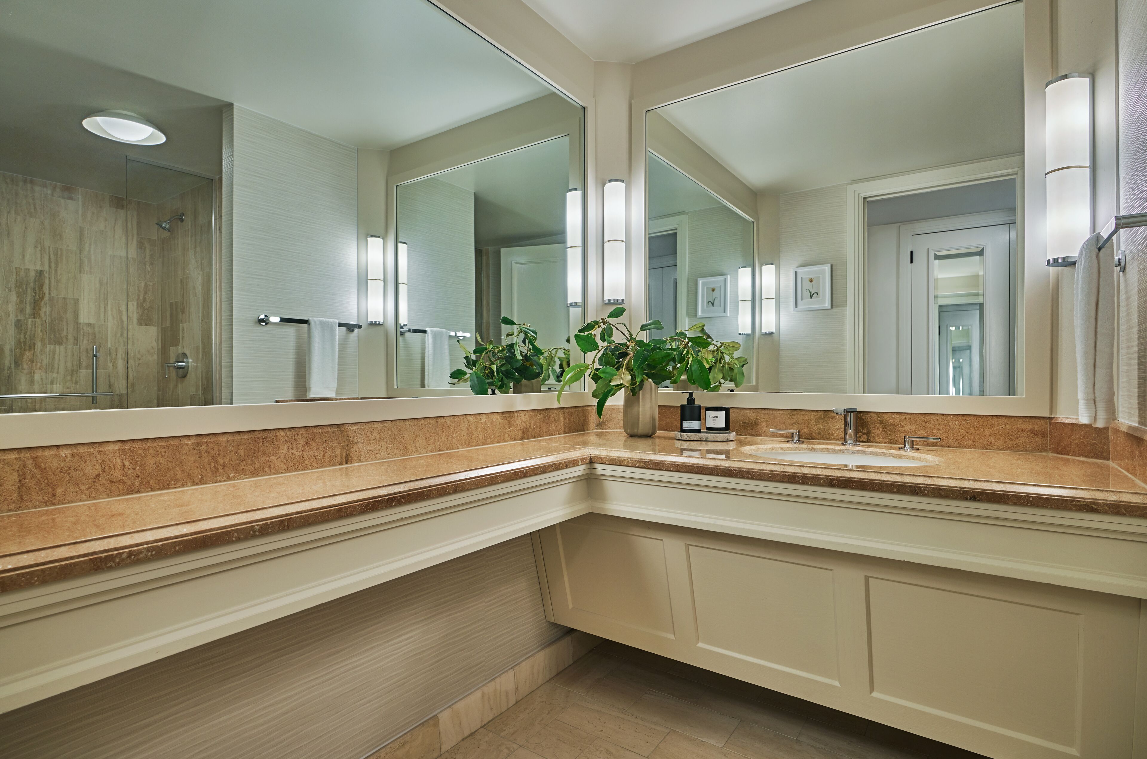 A modern bathroom with a large mirror, a sink, and a shower.