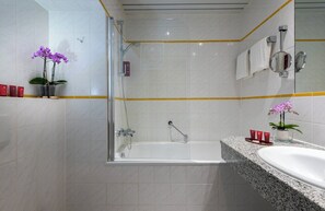 A modern bathroom with a glass-enclosed shower, a freestanding bathtub, and a granite countertop. - Leonardo Frankfurt City South (Frankfurt)