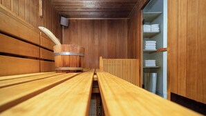 Un sauna con bancos de madera y un balde de madera.
