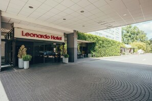 The entrance of the Leonardo Hotel with a paved driveway leading to the entrance. - Leonardo Frankfurt City South (Frankfurt)