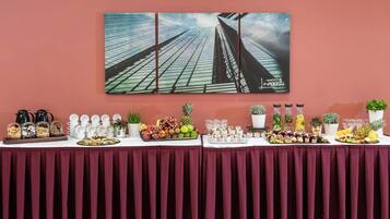 Ein Buffet mit verschiedenen Speisen und dahinter ein Gemälde von Wolkenkratzern an der Wand.