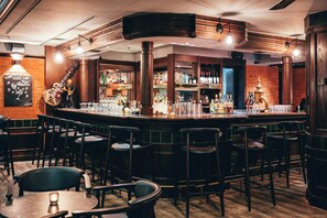 A bar area with wooden accents, a variety of bottles, and a guitar decoration.