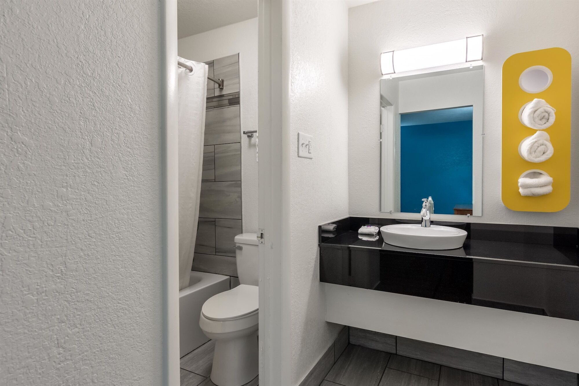 A modern bathroom with a toilet, sink, and shower.