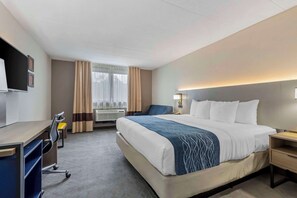 Relax in comfort with a large bed, desk, and TV in this cozy space.