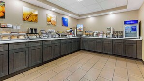 A spacious kitchen area with a long counter, equipped with various appliances and food items. - Comfort Inn Herndon - Reston (Herndon)
