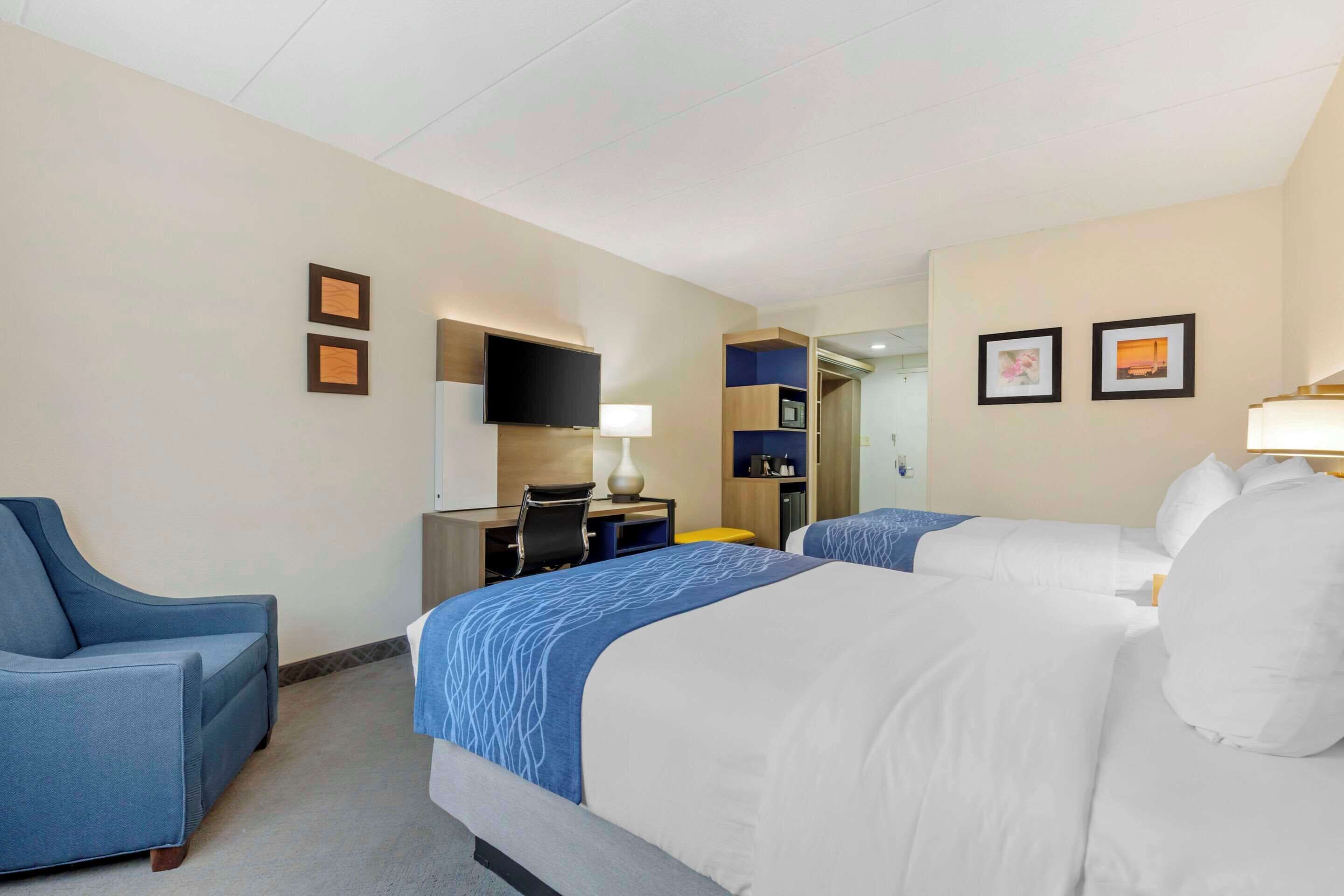 Een hotelkamer met een bed, bureau, stoel en televisie.