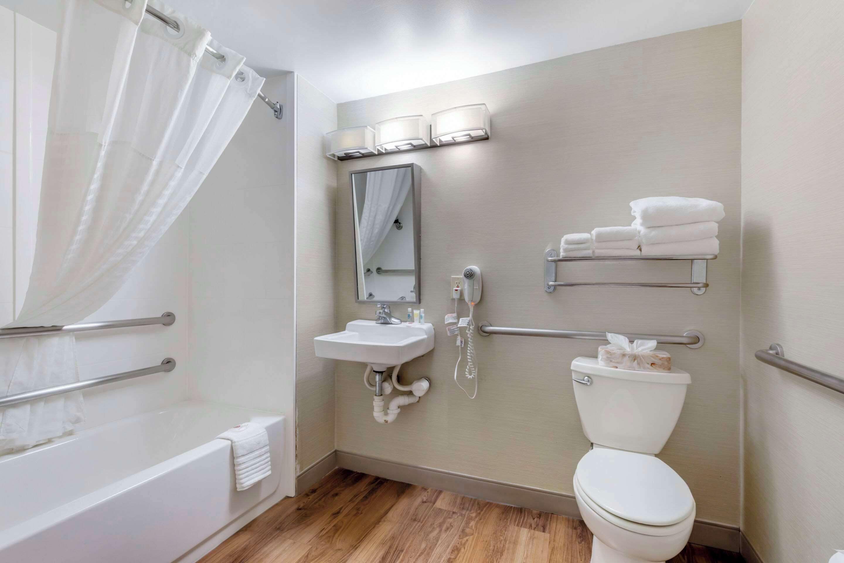 Un baño con bañera, lavabo, inodoro y cortina de ducha.
