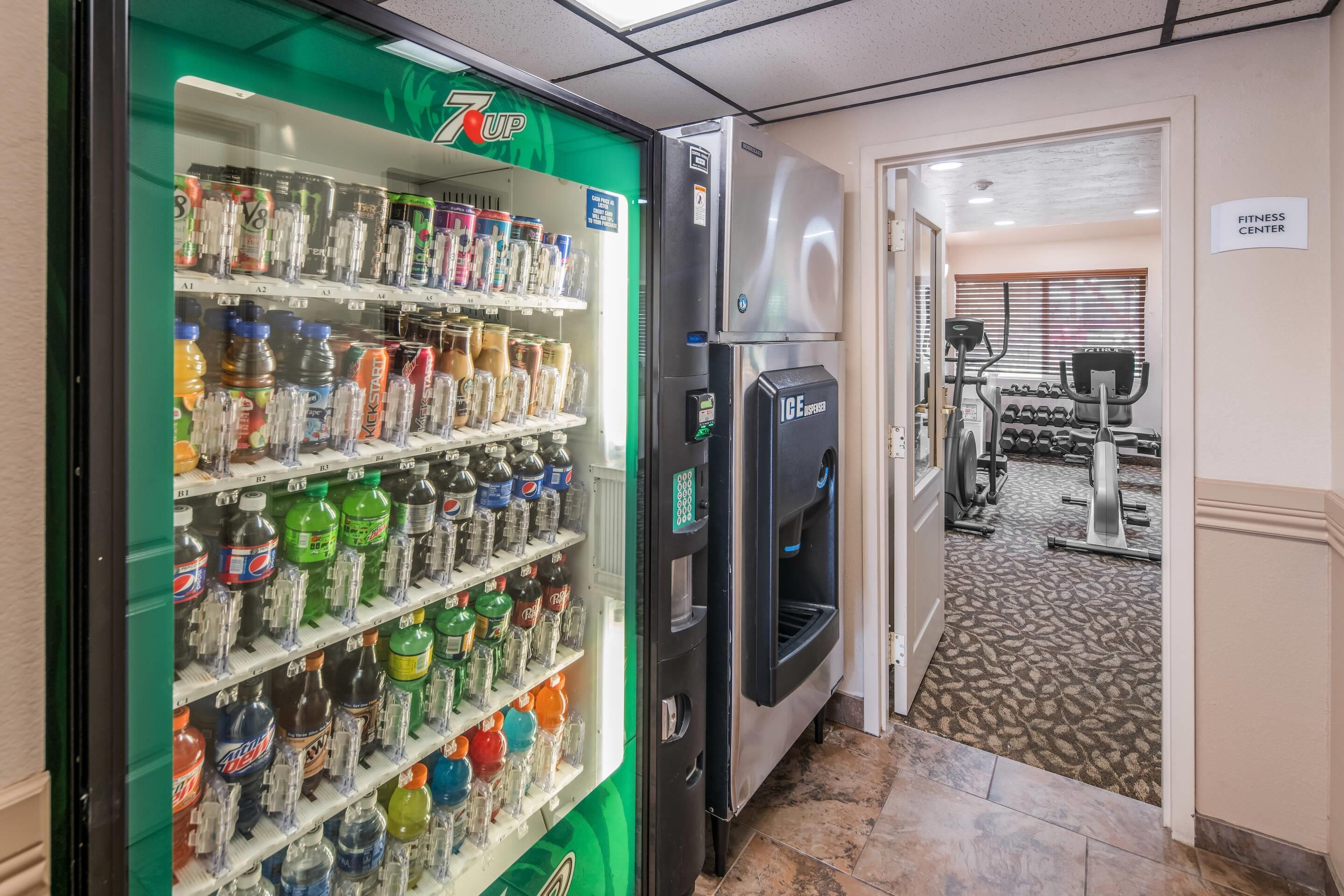 Máquina expendedora llena de diversas bebidas y un refrigerador.