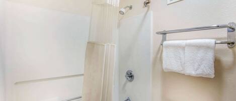 A bathroom with a shower, a toilet, and a towel rack.