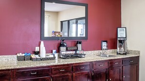 Ein Hotelzimmer mit einem großen Spiegel, einer Kaffeemaschine, einer Warmwasserstation und einem Hinweis darauf, dass Rauchen in ausgewiesenen Bereichen erlaubt ist.